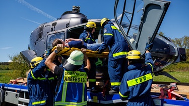 Ehrenamtliche Helfer des Technischen Hilfswerks (THW) bergen während der Katastrophenschutzübung Insassen aus einem notgelandeten Hubschrauber.  | Bild: picture alliance/dpa | Daniel Karmann 